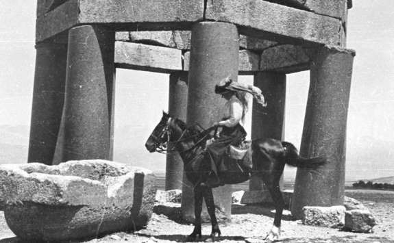 A black and white photograph of Gertrude Bell on a horse